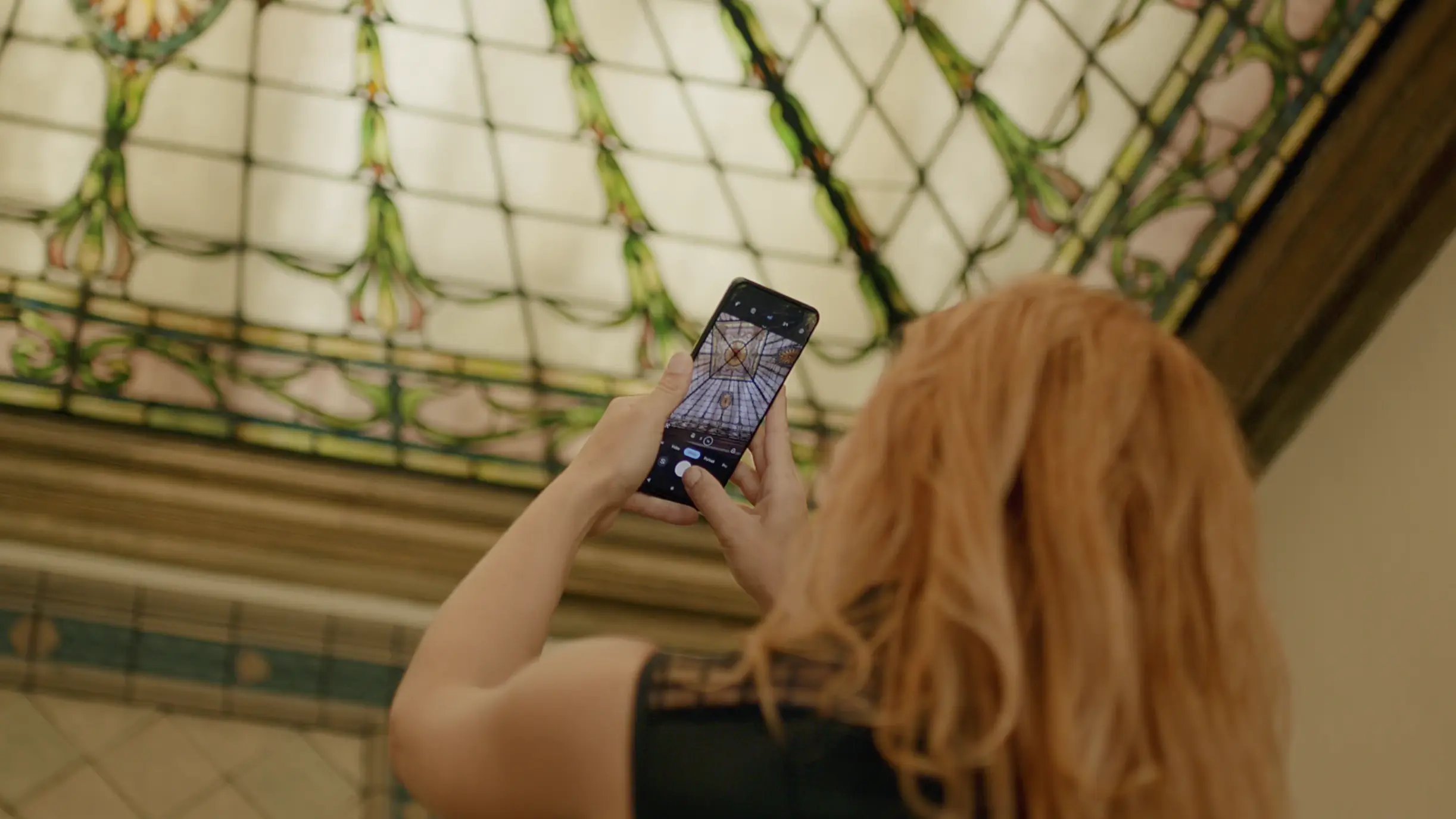 woman taking picture of stained glass