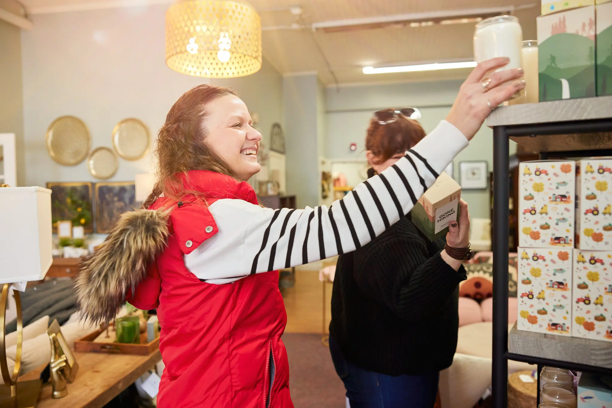woman picking candle off shelf